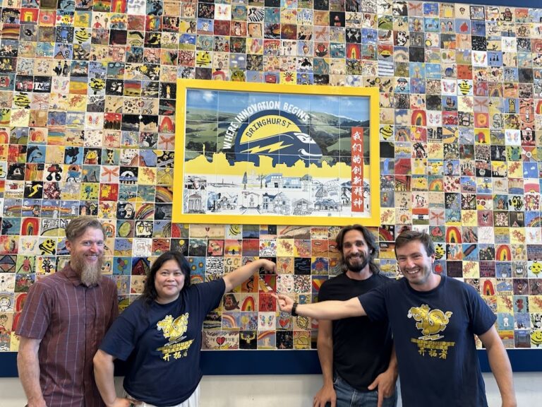 people standing in front of tile mural