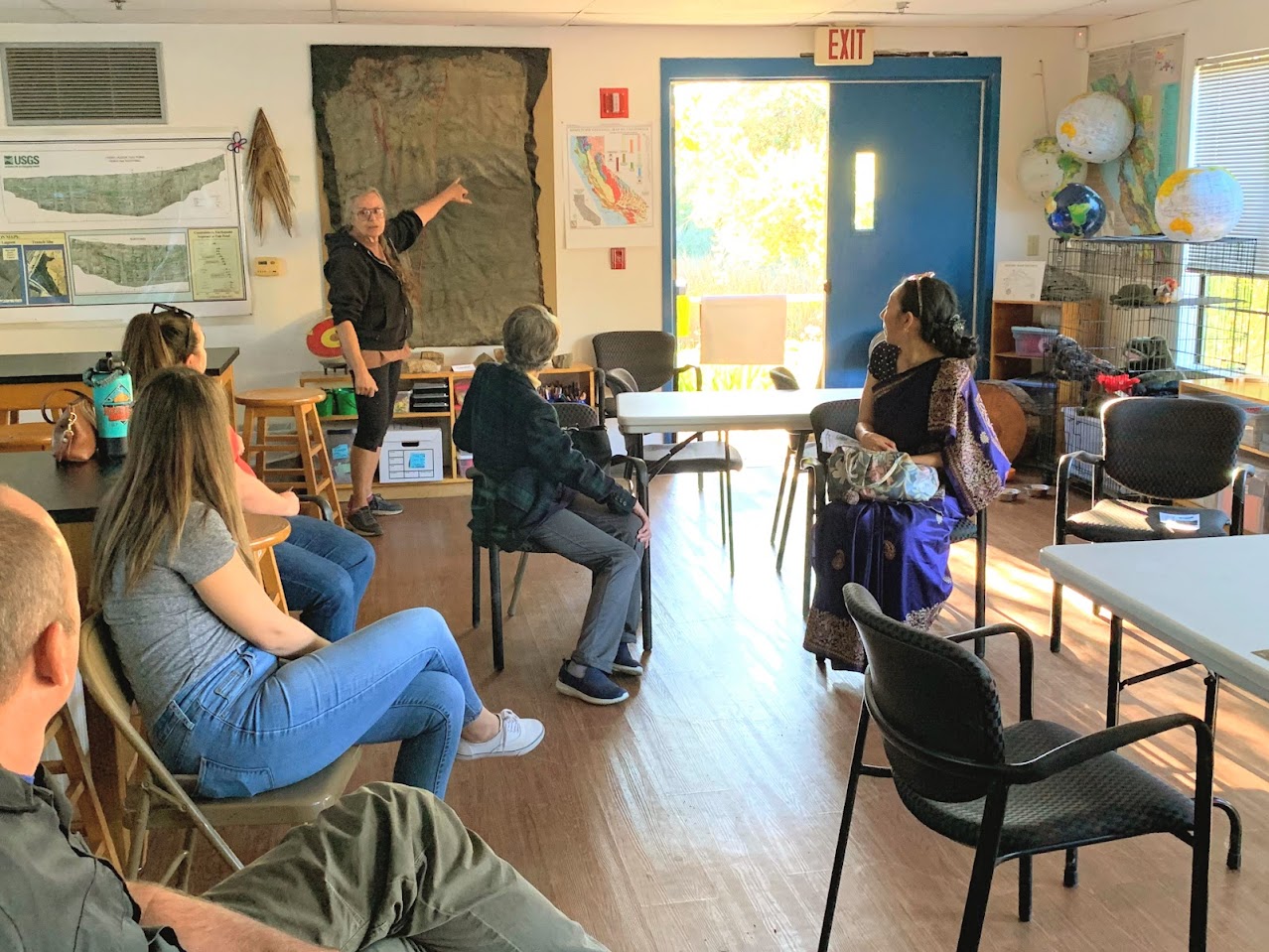 adults in learning space with person pointing to and talking about map