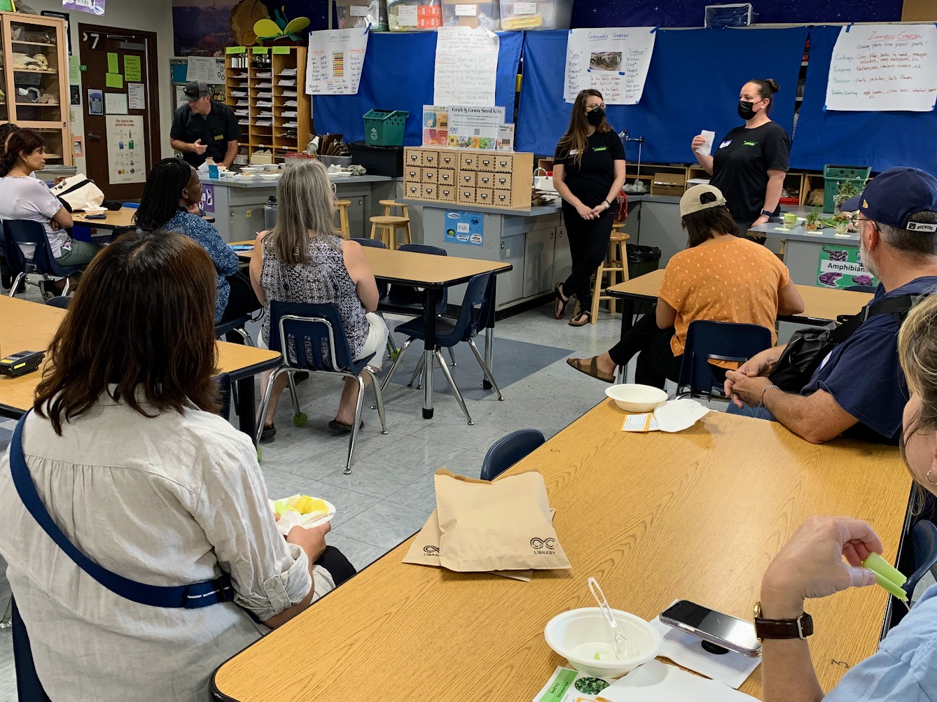 adults in classroom with presenters at front of room